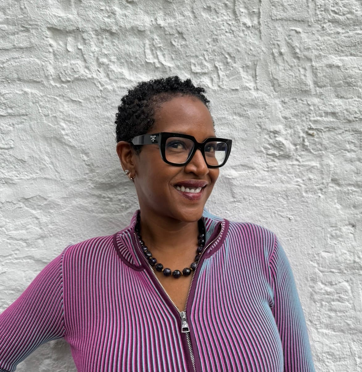 Krystal K. Thompson, fondatrice de KUPONYA, contre un mur blanchi à la chaux.